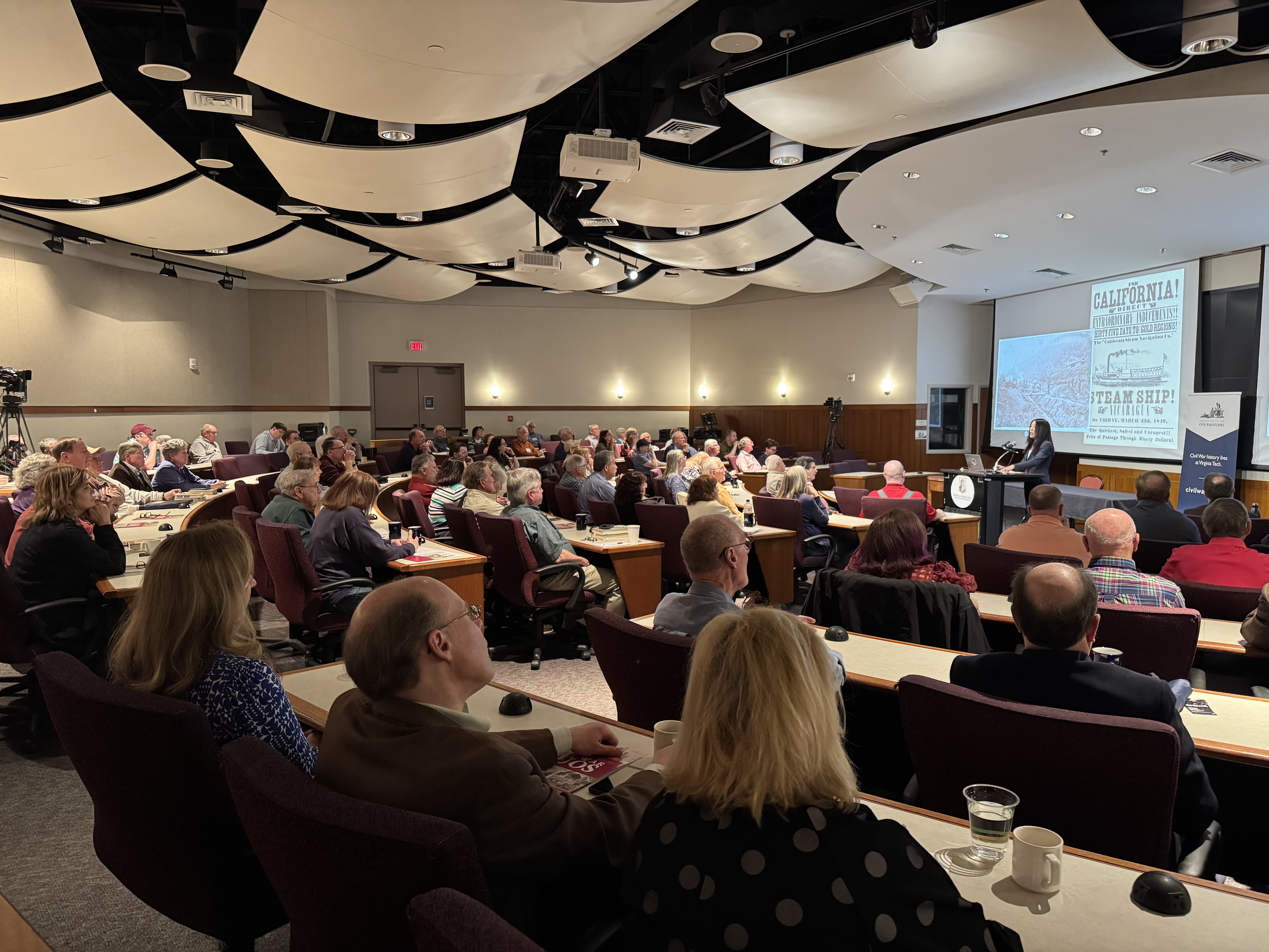 Dr. Ilyon Woo speaking to a room of more than 100 people